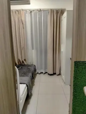 a room with a bed and a window with curtains at SMDC Apartment in FAME in Manila