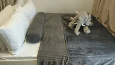 a stuffed elephant is laying on a bed at SMDC Apartment in FAME in Manila