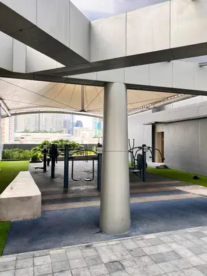 a large white building with a bench and picnic tables at SMDC Fame Condo in Manila