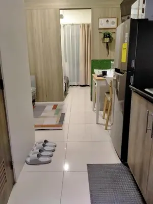 a kitchen with a white tile floor with a refrigerator at SMDC Fame Residences in Manila