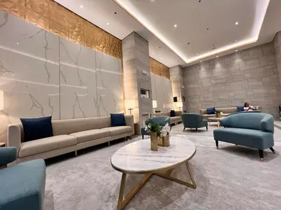 a lobby with couches and chairs and a table at SMDC Fame Residences in Manila