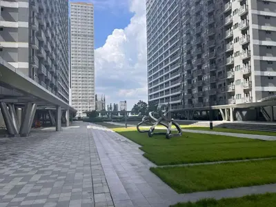 a statue of a boy sitting on a playground in a city at SMDC Fame Residences in Manila
