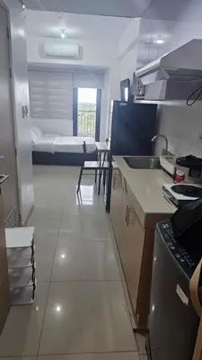 a room with a kitchen with a bed in the background at Smdc green 2 residence in Pasong Bayog