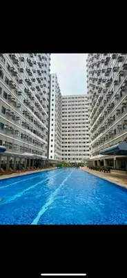 a large swimming pool in front of two large buildings at Smdc green 2 residence in Pasong Bayog