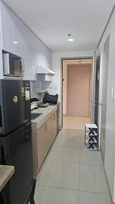 a kitchen with a black refrigerator and a counter at Smdc green 2 residence in Pasong Bayog