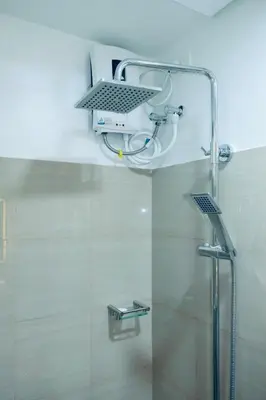 a shower in a bathroom with a glass door at Serene Stays at Shore in Manila