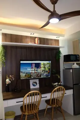 a living room with a desk with two chairs and a tv at Serene Stays at Shore in Manila