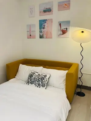 a bedroom with a bed with a lamp and pictures on the wall at Serene Stays at Shore in Manila