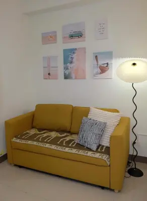 a couch in a living room with a lamp and pictures at Serene Stays at Shore in Manila