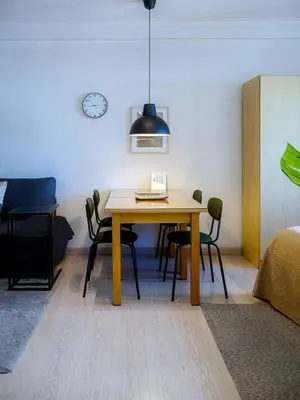 a dining room table with chairs and a clock on the wall at Private Modern Condo in BGC in Manila