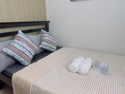 a bed with two towels and pillows on it at Shore Residence by CozyHaven's Homestay in Manila