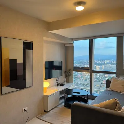 a living room with a bed and a large window at Elegant 1BR with Great View, Panoramic Pool Near Ortigas CBD - 24 in Manila