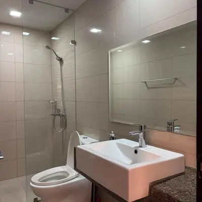 a bathroom with a sink and a toilet and a mirror at Elegant 1BR with Great View, Panoramic Pool Near Ortigas CBD - 24 in Manila