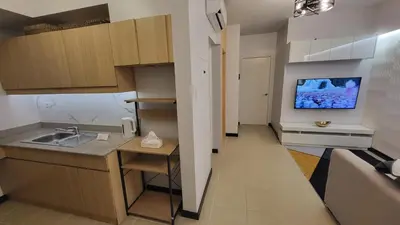 a small kitchen with a sink and a tv on the wall at The Atherton- Spacious Modern Condo Unit in Paranaque Near the Airport, Makati, BGC and Highways in Manila