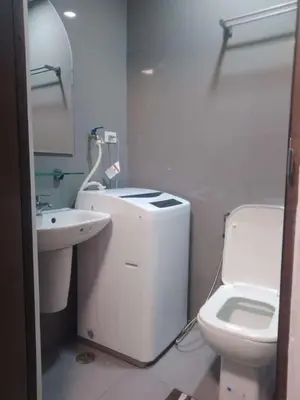 a white bathroom with a sink and a toilet at Casa Beatrice Staycation in Manila