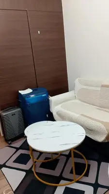 a room with a bed and a table and a suitcase at Casa Beatrice Staycation in Manila