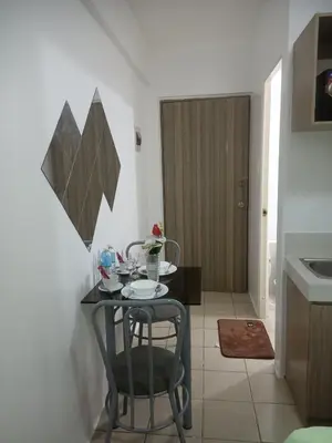 a small table and chairs in a room with a kitchen at Urban deca tower by jas airways in Manila