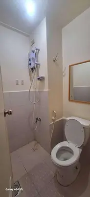 a bathroom with a toilet and a shower at Urban deca tower by jas airways in Manila