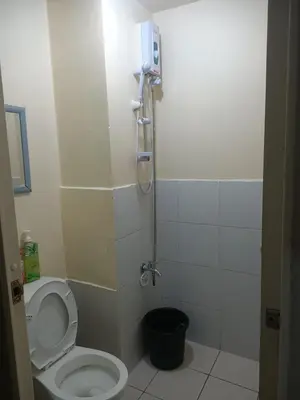a small bathroom with a toilet and a shower at Urban deca tower by jas airways in Manila