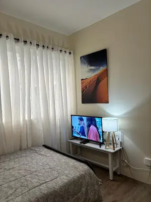 a bedroom with a bed and a television on a table at C homestay fullerton suites in Silang