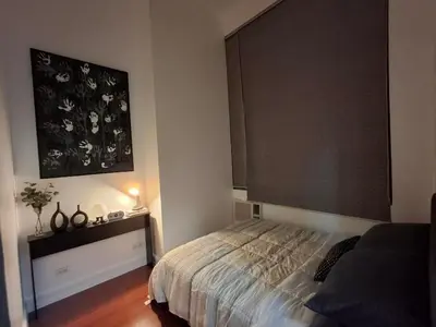 a bedroom with a bed and a painting on the wall at Forbeswood Garden Suite Parklane BGC in Manila
