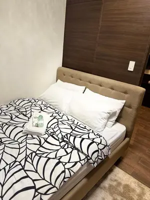 a bed with a black and white comforter and pillows at Condo in Makati, Casa Beatrice in Manila