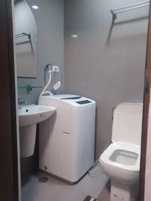 a white bathroom with a sink and a toilet at Condo in Makati, Casa Beatrice in Manila