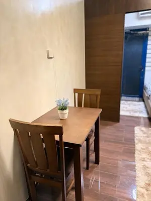 a wooden table with two chairs and a potted plant on it at Condo in Makati, Casa Beatrice in Manila