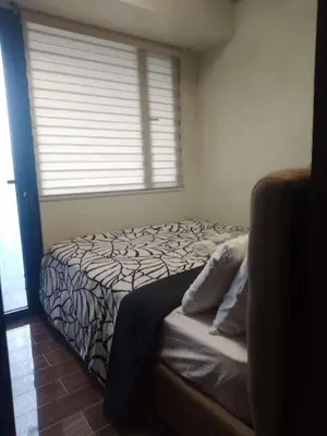 a bed in a room with a window at Condo in Makati, Casa Beatrice in Manila