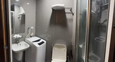 a small bathroom with a toilet and a sink at Condo in Makati, Casa Beatrice in Manila