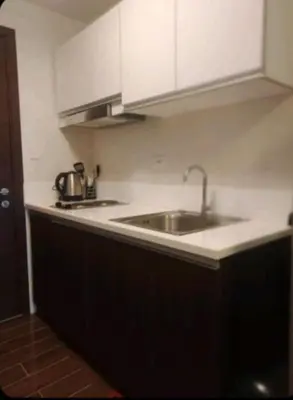 a kitchen with a sink and white cabinets at Condo in Makati, Casa Beatrice in Manila