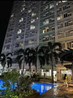 a large building with palm trees in front of it at Casa Lily in Manila