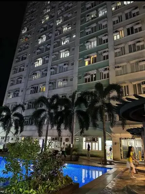 a large building with palm trees in front of it at Casa Lily in Manila