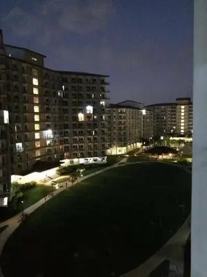a night view of a large park in front of a building at Field Residence Staycation in Manila