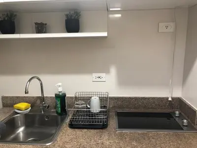 a kitchen counter top with a sink and a sink at Field Residence Staycation in Manila