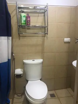 a bathroom with a white toilet and a sink at Field Residence Staycation in Manila