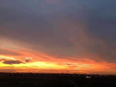 a sunset with a plane in the sky at Field Residence Staycation in Manila
