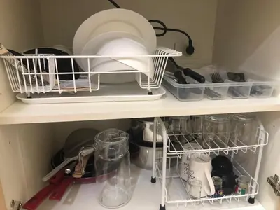 a kitchen shelf with dishes and other kitchen utensils at Field Residence Staycation in Manila