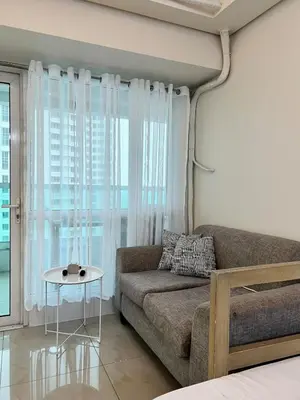 a living room with a couch and a table at Tower 1 Rm 305 FREE Parking, FREE Pool, Balcony, 1Bedroom 4 beds in Manila