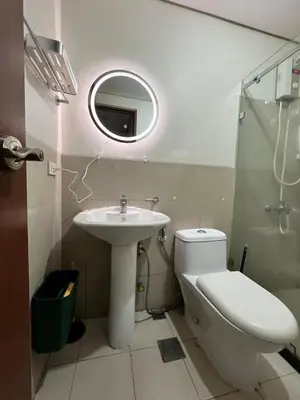 a bathroom with a sink and a toilet and a mirror at Tower 1 Rm 305 FREE Parking, FREE Pool, Balcony, 1Bedroom 4 beds in Manila