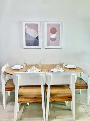 a dining room with a table with white chairs at Tower 1 Rm 305 FREE Parking, FREE Pool, Balcony, 1Bedroom 4 beds in Manila