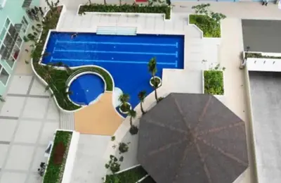an overhead view of a swimming pool with an umbrella at M&M Suites Ridgewood Towers T3 BGC McKinley in Manila