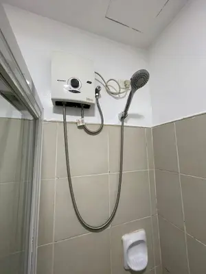 a shower with a shower head in a bathroom at M&M Suites Ridgewood Towers T3 BGC McKinley in Manila