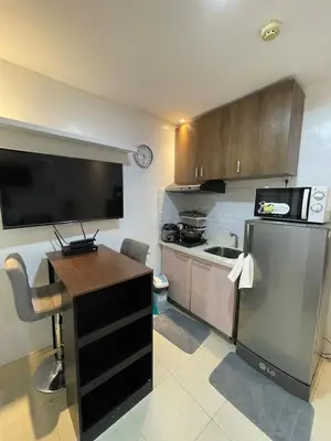 a small kitchen with a refrigerator and a sink at M&M Suites Ridgewood Towers T3 BGC McKinley in Manila
