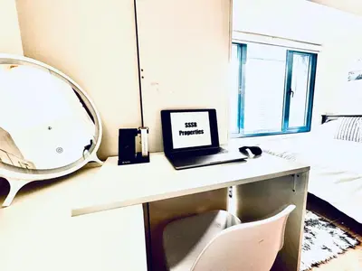 a room with a desk with a laptop and a mirror at Luxurious 2 Bedroom Oasis in Air Residences with Bar KTV and Games in Manila