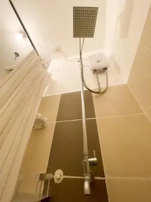 a shower in a bathroom with a tile floor at Houzz 1548 by Houzztelity in Manila