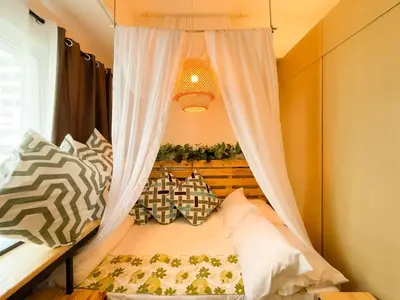 a bedroom with a canopy bed with curtains and pillows at Houzz 845 by Houzztelity in Manila