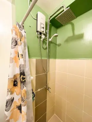 a shower with a shower curtain in a bathroom at Houzz 845 by Houzztelity in Manila