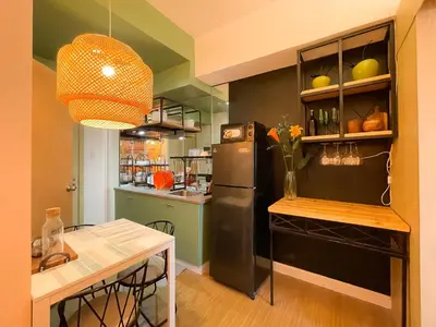 a kitchen with a black refrigerator and a table at Houzz 845 by Houzztelity in Manila