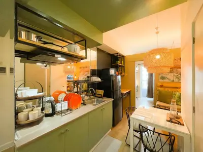 a kitchen with a counter and a table with chairs at Houzz 845 by Houzztelity in Manila